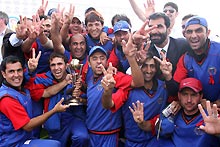 Afghanistan celebrate with the trophy after their two-wicket victory in the Final against Jersey.